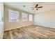 Bright living room with wood-look floors, neutral walls, ceiling fan, and multiple windows at 5024 Stone Bay Ave, Las Vegas, NV 89131