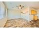 Open-concept living room with wood-look flooring, ceiling fan, and adjacent kitchenette at 5024 Stone Bay Ave, Las Vegas, NV 89131