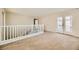 Bright open loft area with carpet flooring and a stairway with white railing to the second floor at 5024 Stone Bay Ave, Las Vegas, NV 89131