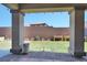 Backyard featuring a covered patio, low brick wall, garden boxes and well-maintained lawn at 5555 E San Pietro Dr, Pahrump, NV 89061