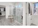 Bright bathroom featuring a glass-enclosed walk-in shower with a wooden bench and a neutral-toned rug at 5555 E San Pietro Dr, Pahrump, NV 89061
