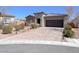 Beautiful single-story home with a paver driveway, desert landscaping, and an attached two-car garage at 5555 E San Pietro Dr, Pahrump, NV 89061