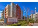 Manhattan Condominiums exterior view featuring a building sign and landscaped greenery at 56 E Serene Ave # 306, Las Vegas, NV 89123