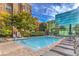 Community pool with seating and a view of the glass building at 56 E Serene Ave # 306, Las Vegas, NV 89123