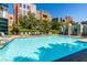Large community pool with lounge chairs, umbrellas, and manicured landscaping at 56 E Serene Ave # 306, Las Vegas, NV 89123