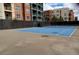 Outdoor tennis court with an adjacent fence and multi-story apartment homes in the background at 56 E Serene Ave # 306, Las Vegas, NV 89123
