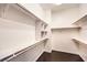 Organized walk-in closet featuring shelving, wooden rods, and dark hardwood flooring at 56 E Serene Ave # 306, Las Vegas, NV 89123