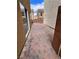 View of the brick-paved backyard with stucco walls on either side at 566 Shewsbury Ave, Las Vegas, NV 89178