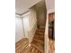 Elegant staircase featuring wood-look flooring, white railing, and an adjacent kitchen for convenient access to upper levels at 566 Shewsbury Ave, Las Vegas, NV 89178