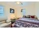 Cozy bedroom with a decorative bedspread, bedside table, and comfortable armchair at 5916 Sierra Cliff St, North Las Vegas, NV 89031