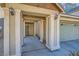 Covered front porch featuring sturdy support columns, outdoor lighting, and convenient access to the two-car garage at 5916 Sierra Cliff St, North Las Vegas, NV 89031