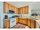 Functional kitchen featuring a gas stove, wood cabinets and a view to the outside at 5916 Sierra Cliff St, North Las Vegas, NV 89031