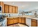 Traditional kitchen features wood cabinetry, white appliances, and tile floors for easy maintenance and a homey feel at 5916 Sierra Cliff St, North Las Vegas, NV 89031