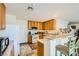 Efficient kitchen includes wood cabinets, white appliances, and breakfast bar seating for a comfortable dining experience at 5916 Sierra Cliff St, North Las Vegas, NV 89031