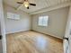 Bright bedroom featuring a ceiling fan, two windows, light wood-look floors, and white trim at 604 N Minnesota St, Las Vegas, NV 89107