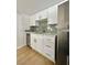 Updated kitchen with white cabinets, stainless steel appliances, and stylish backsplash at 604 N Minnesota St, Las Vegas, NV 89107