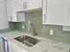 Updated kitchen featuring a stainless steel sink, faucet, and stylish backsplash at 604 N Minnesota St, Las Vegas, NV 89107