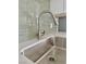 Close-up of a modern kitchen faucet featuring quartz countertops and a stylish backsplash at 604 N Minnesota St, Las Vegas, NV 89107