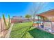 Lush backyard with green grass, a small tree, and a covered patio area at 637 Del Prado Dr, Boulder City, NV 89005