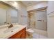 Bright bathroom with wood vanity, tile floors, and a shower-tub combo with sliding glass doors at 637 Del Prado Dr, Boulder City, NV 89005
