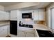Bright kitchen features white cabinets, black appliances, and tiled countertops with a modern range at 637 Del Prado Dr, Boulder City, NV 89005