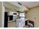 Efficient kitchen with white tile counters, black appliances, and a breakfast bar overlooking the dining area at 637 Del Prado Dr, Boulder City, NV 89005