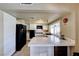 Updated kitchen with white cabinetry, sleek black appliances, and breakfast bar overlooking the living area at 637 Del Prado Dr, Boulder City, NV 89005
