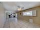 Spacious living room with ceiling fan and tile floors leading into a kitchen area at 637 Del Prado Dr, Boulder City, NV 89005