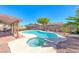 Backyard oasis with a kidney-shaped pool, spa, covered patio, and desert landscaping at 637 Del Prado Dr, Boulder City, NV 89005