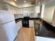 This modern kitchen offers white cabinets, sleek black countertops, and stainless steel appliances at 6800 E Lake Mead Blvd # 2011, Las Vegas, NV 89156