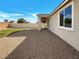 Wide shot of the backyard featuring a patio, gravel, and grass for a low maintenance landscape at 7024 Whispering Falls Dr, North Las Vegas, NV 89084