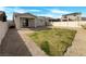 Fenced backyard with a small grass area and low-maintenance desert landscaping at 7024 Whispering Falls Dr, North Las Vegas, NV 89084