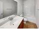 Well-lit bathroom featuring a large vanity mirror, ceramic tile flooring, and a shower-tub combination at 7024 Whispering Falls Dr, North Las Vegas, NV 89084