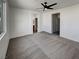 Bright bedroom boasting neutral carpeting, a ceiling fan, and access to a bathroom and hallway at 7024 Whispering Falls Dr, North Las Vegas, NV 89084