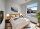 Cozy bedroom with a queen-size bed, nightstands, and a large window with a neighborhood view at 7024 Whispering Falls Dr, North Las Vegas, NV 89084