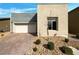 Contemporary home with a two-car garage, brick driveway, and low-maintenance landscaping at 7024 Whispering Falls Dr, North Las Vegas, NV 89084