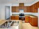 Functional kitchen with wood cabinets, granite countertops, and stainless steel appliances at 7024 Whispering Falls Dr, North Las Vegas, NV 89084