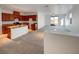 Bright and airy living room featuring an open floor plan, carpeted floors, and stainless steel kitchen appliances at 7024 Whispering Falls Dr, North Las Vegas, NV 89084