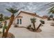 Charming single-story home with a red tile roof, mature palm trees, and a winding concrete walkway at 7413 Turtle Dove Ct, Las Vegas, NV 89129