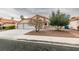 Front exterior of a single-Gathering home with a two-car garage, desert landscaping, and mature trees at 7413 Turtle Dove Ct, Las Vegas, NV 89129