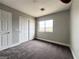 Bedroom with neutral walls, carpet, window, closet, and door at 7696 Mocorito Ave, Las Vegas, NV 89113