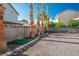A private backyard is graveled, edged in stone, with mature trees, and enclosed by a block wall for privacy at 7820 Esteem St, Las Vegas, NV 89131