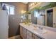 Bathroom featuring double sinks, a large mirror, and cabinets for storage at 7820 Esteem St, Las Vegas, NV 89131