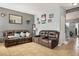 Comfortable living room has a leather sofa set, neutral paint, tile flooring and plenty of room at 7820 Esteem St, Las Vegas, NV 89131
