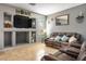 A cozy living room features a modern built-in media center, tile floors, and a comfortable leather sofa at 7820 Esteem St, Las Vegas, NV 89131