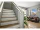 Well-lit staircase leads to the living room, featuring tile floors, neutral paint, and bright natural light at 7820 Esteem St, Las Vegas, NV 89131