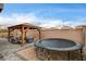 This backyard features a gazebo with seating, a trampoline, and rock landscaping at 7828 Stone Forest St, North Las Vegas, NV 89084