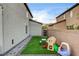 This backyard features artificial grass, a walkway, and a play area at 7828 Stone Forest St, North Las Vegas, NV 89084