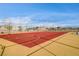 This is a red basketball court with multiple hoops, surrounded by a fence at 7828 Stone Forest St, North Las Vegas, NV 89084