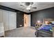 Comfortable bedroom featuring a dark-themed wall, ceiling fan, and plush carpeting at 7828 Stone Forest St, North Las Vegas, NV 89084